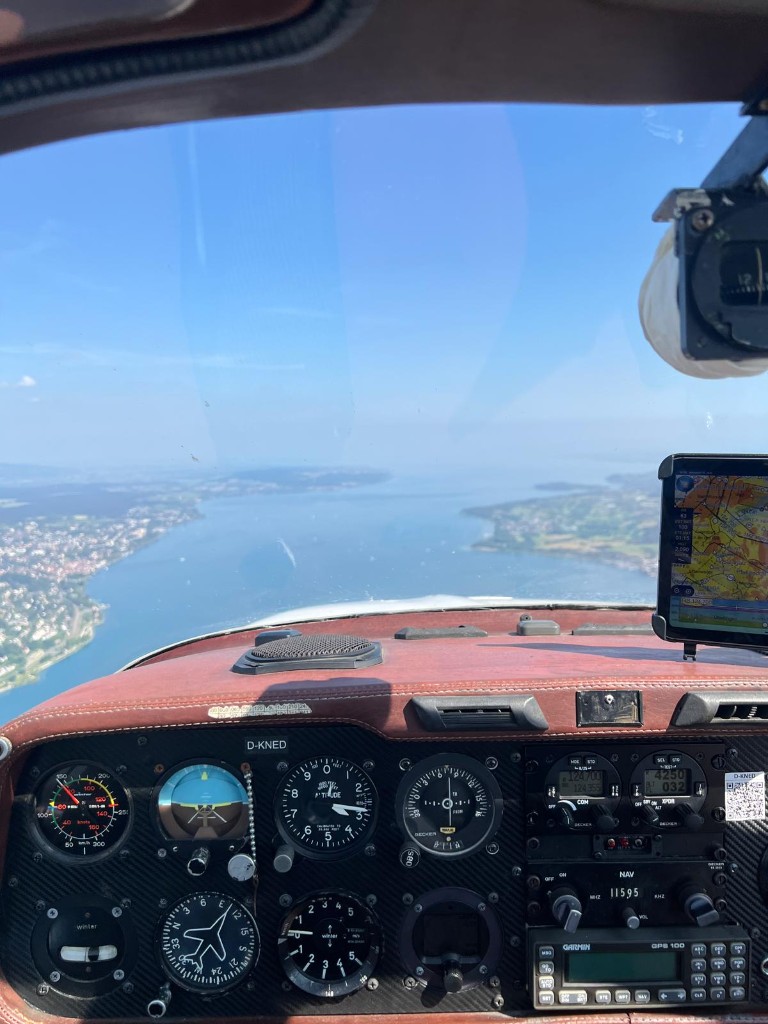 Cockpitblick aus D-KNED über einer Seenlandschaft