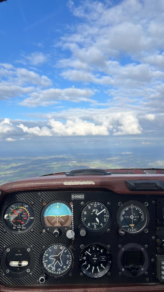 Blick aus dem Cockpit der D-KNED über Wolken