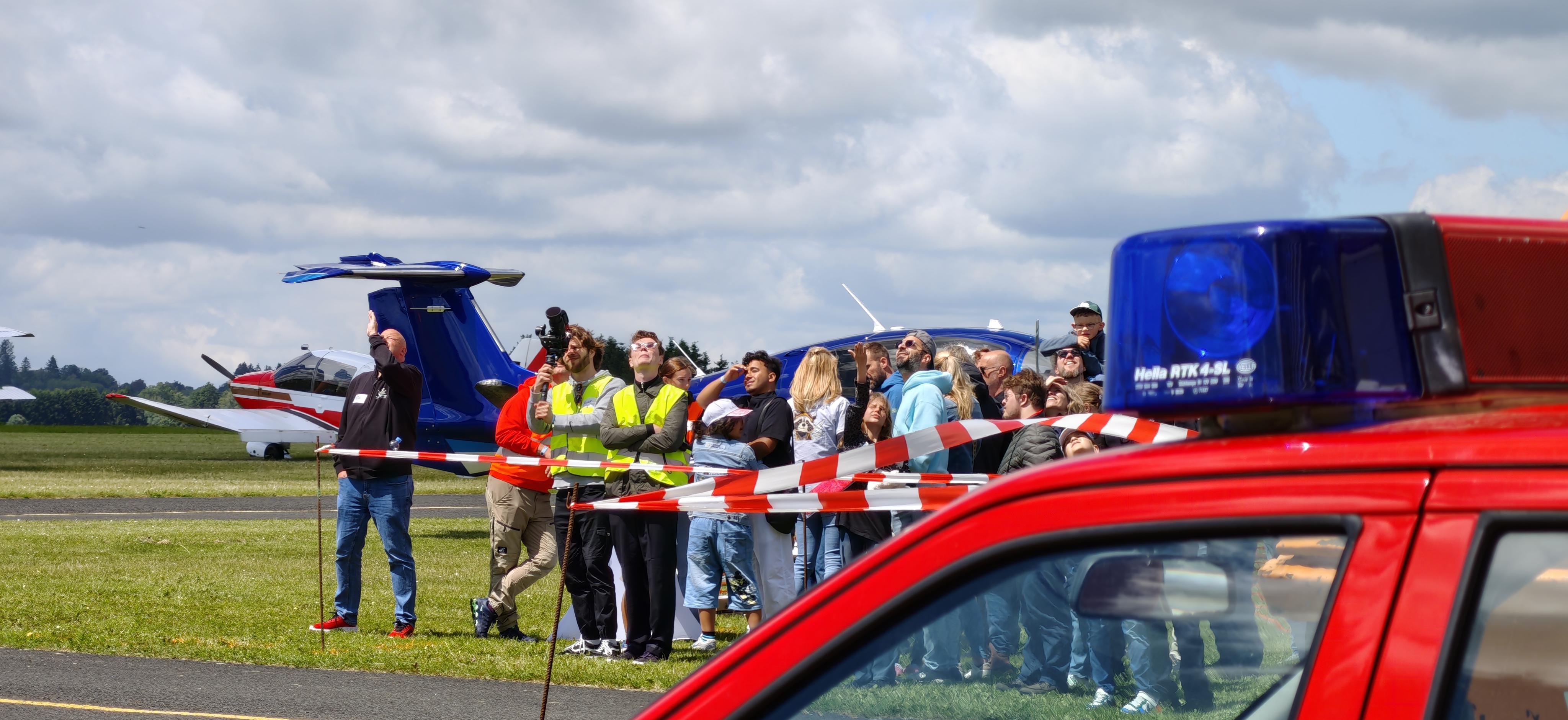Publikum am Verkehrslandeplatz Breitscheid mit Polizeihubschrauber im Hintergrund