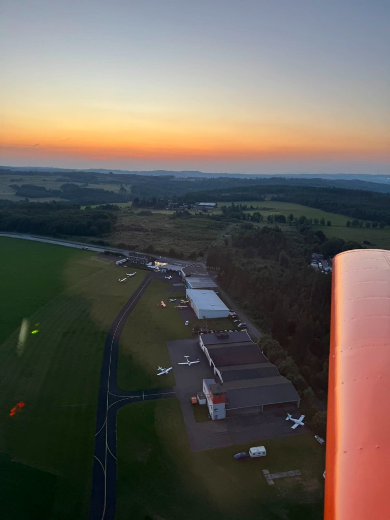 Luftaufnahme der Flugplatzgebäude und Hangars von EDGB im abendlichen Dämmerlicht