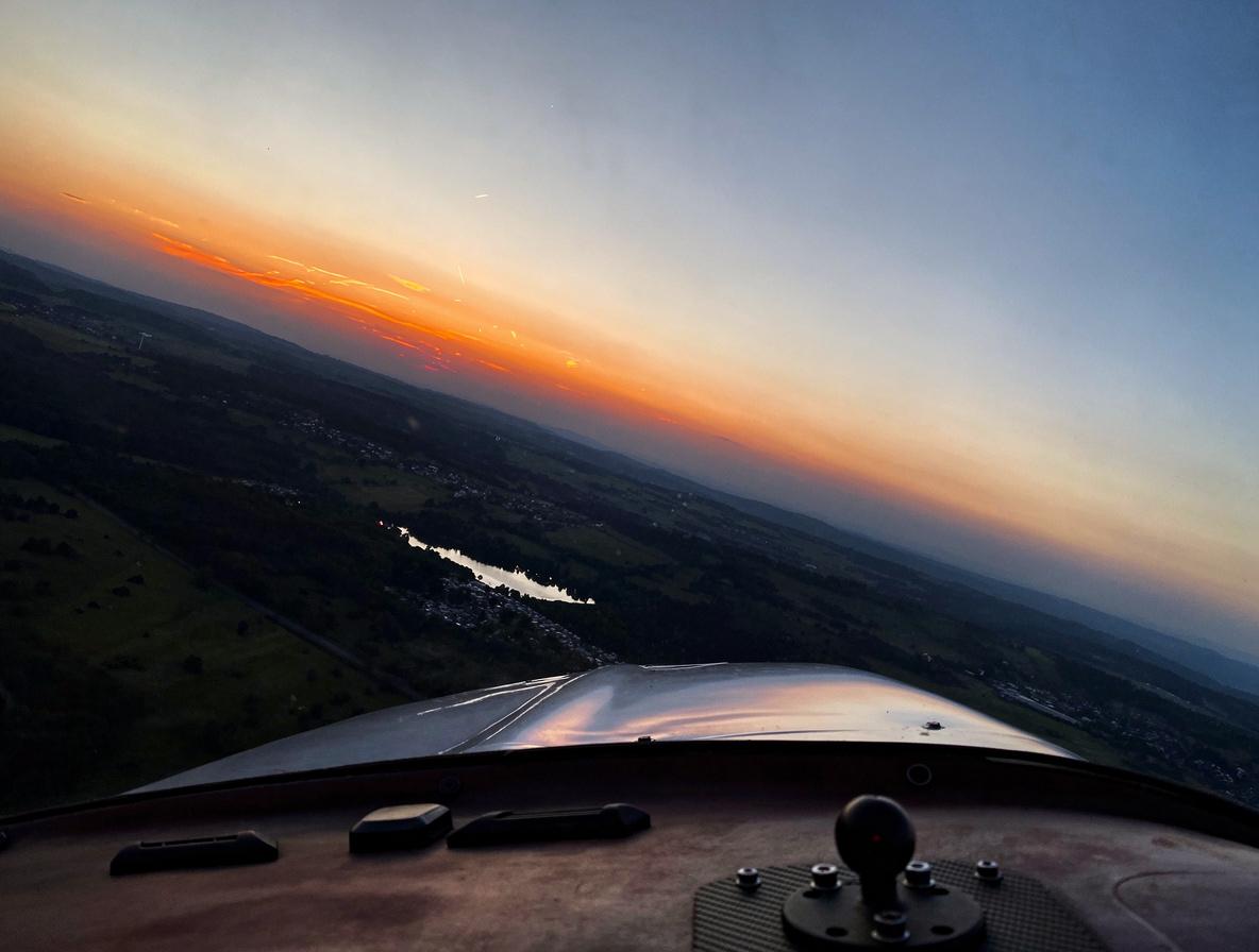 Faszinierendes Fluggefühl: Der Blick aus der Pilotenkanzel in die goldene Stunde über der Region