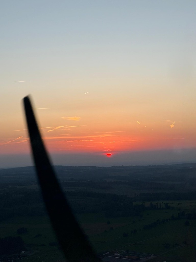 Silhouette der Luftschraube und des Triebwerksraums im tiefroten Sonnenuntergang